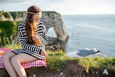 一个女人在岩石海岸野餐
