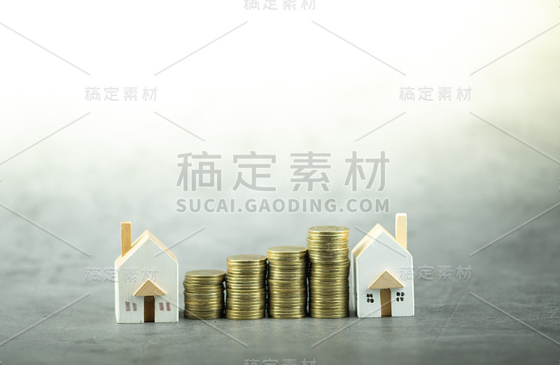 一个有一堆金币的小房子模型。房产投资或住房贷款