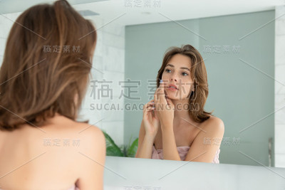 美丽的女人在脸上涂护肤霜