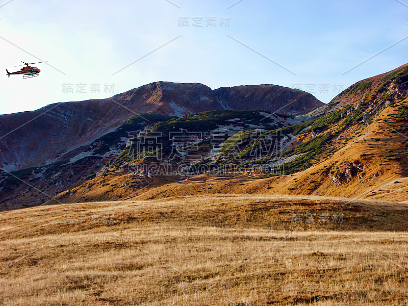 红色直升机在山上飞行