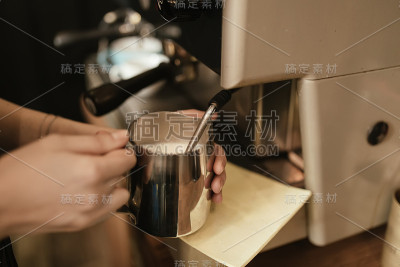 咖啡师在咖啡馆里蒸牛奶