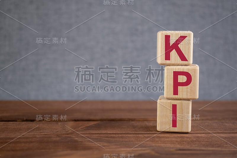 KPI(关键绩效指标)首字母缩略词在木制立方体上的深色木制背景。经营理念。