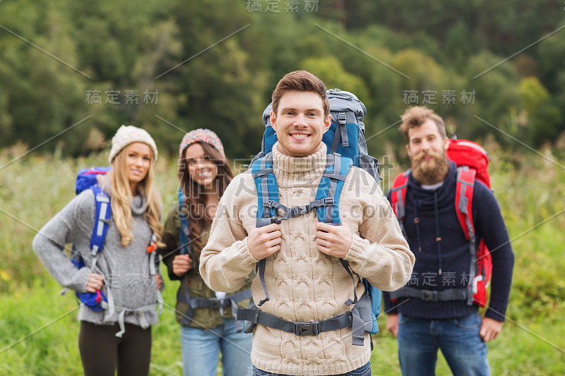 一群背着背包微笑的朋友徒步旅行