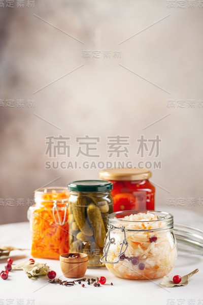 发酵腌菜食品概念。厨房桌子上的玻璃罐子里装满了发酵的、腌制的和罐装的蔬菜。保护农业有机季节性收获。自