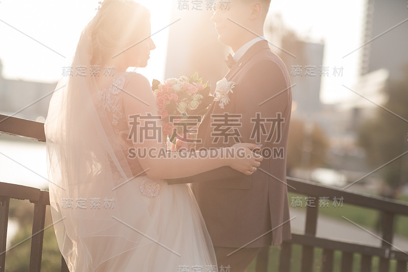 一对幸福的新婚夫妇站在桥上。