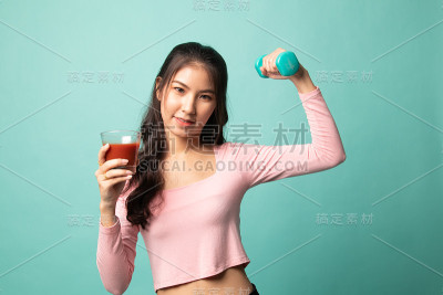 健康的亚洲女人，哑铃和番茄汁。