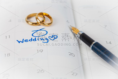 在日历上的婚礼笔记用二人戒指和笔提醒你结婚的日子