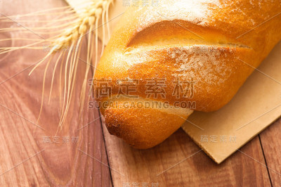 传统的法国长棍面包或面包和小麦茎在木桌上