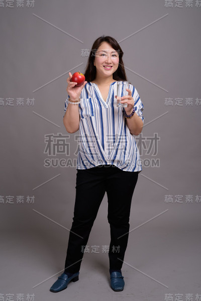 工作室拍摄的成熟美丽的亚洲女商人在灰色的背景