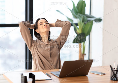 快乐的欧洲女孩在工作场所靠在椅子上