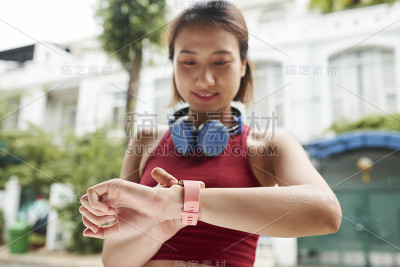 女慢跑者正在检查脉搏
