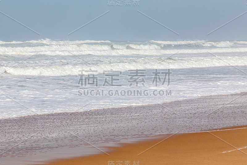 海岸，移动海浪与泡沫。风能。青绿色的水。