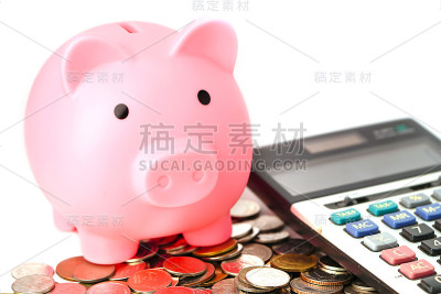 存钱，硬币上的存钱罐和计算器:金融概念。