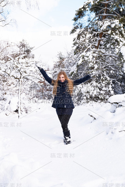 快乐的年轻女子在雪地里玩