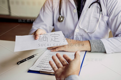 亚洲男医生在医务室交谈，并把处方递给病人。