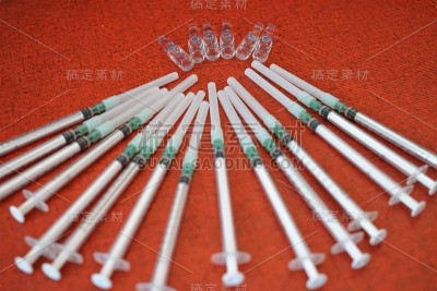 红色背景上的医用安瓿和注射器