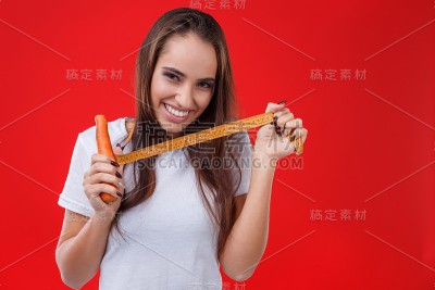 快乐的女孩用胡萝卜和卷尺