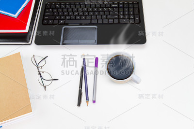 笔记本电脑，眼镜，咖啡杯放在白色的桌子上