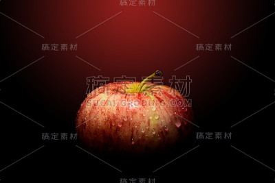 红苹果与水滴在光和阴影在黑色和红色的背景