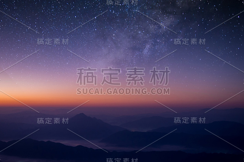 银河在黑暗的夜空中可见。美丽的星空背景与星系星云和美丽的风景，雾蒙蒙的山顶在早晨。