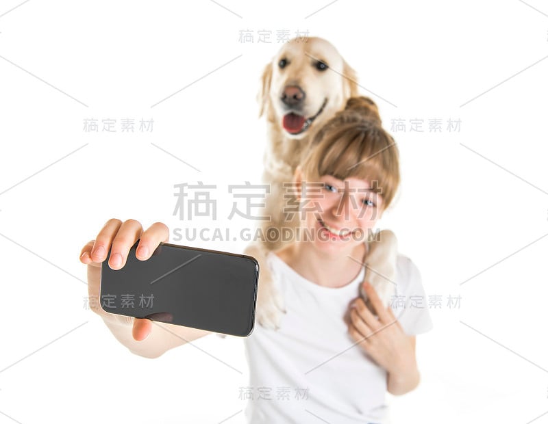 漂亮的少女和她美丽的金毛猎犬在白色的背景做自拍