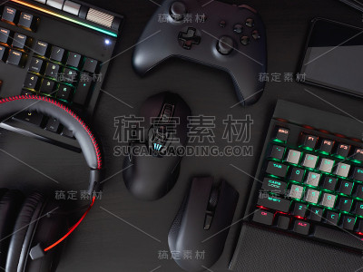玩家工作空间概念，俯视图游戏设备，鼠标，键盘，操纵杆，耳机，移动操纵杆，在耳机和鼠标垫的黑色桌面背景