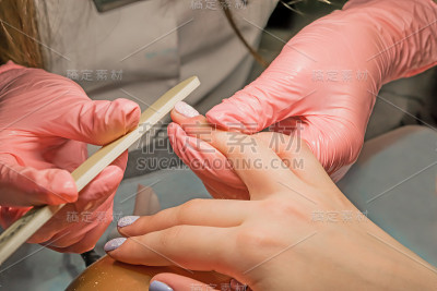 粉红手套师傅正在给一个小女孩修指甲，