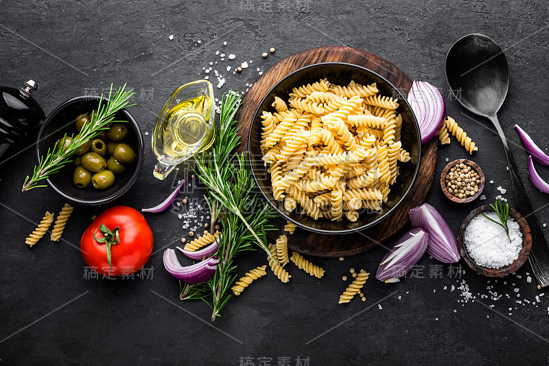 意大利面和配料烹饪黑色背景，俯视图。意大利菜