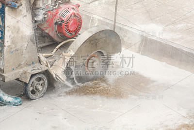 工人在建筑工地使用金刚石锯片机切割混凝土道路
