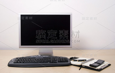 办公室电脑，日历和手机。黑色的屏幕