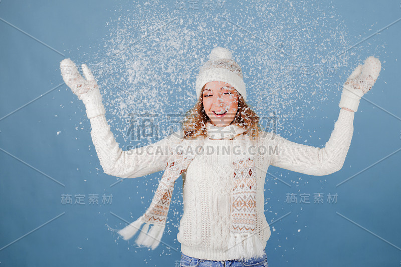 快乐的女孩笑着玩雪。毛针织服装