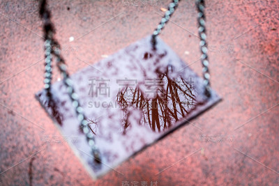 一个潮湿的秋千和上面的倒影