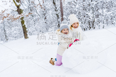 妈妈和可爱的小女儿一起堆雪人