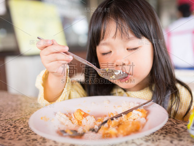 特写泰国小女孩早上在餐厅吃米饭和煎蛋。