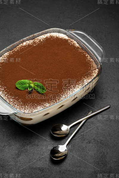 传统的意大利提拉米苏甜点在玻璃烤盘在混凝土背景