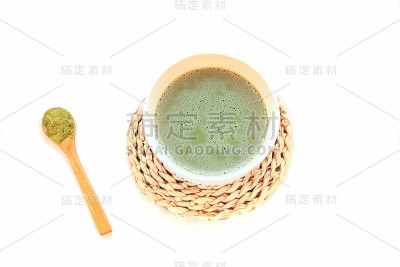 白色桌子上，白色杯子里的抹茶绿茶