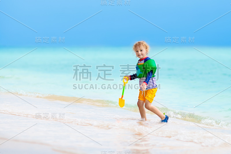 孩子们在热带海滩上玩耍。沙子和水玩具。