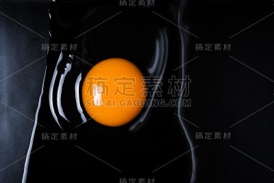鸡蛋和蛋壳在一个黑色盘子上破裂了