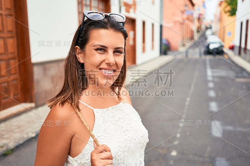 在一个阳光明媚的夏天，年轻美丽的女人快乐地走在城市的街道上