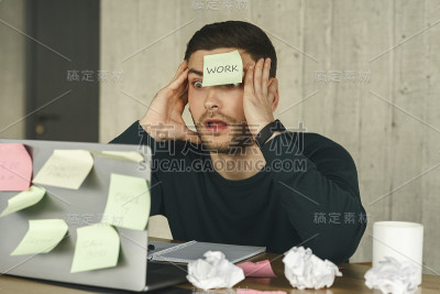 震惊的经理坐在室内到处贴便利贴