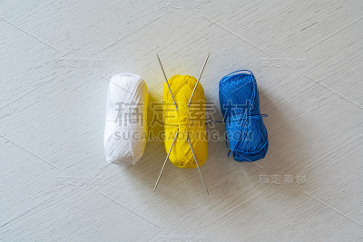 俯视图一些纱线卷与一对针织针插入在桌子上