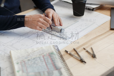 建筑师在办公室里设计蓝图。工程师检查建筑平面图，为建筑工程画草图。长着胡须的英俊男子坐在工作场所的肖