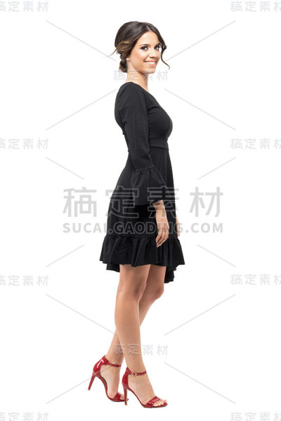 侧面的幸福微笑的西班牙妇女在黑色荷叶边裙看着照相机。