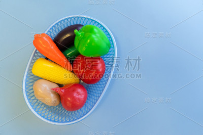 蓝色背景的篮子里的塑料水果