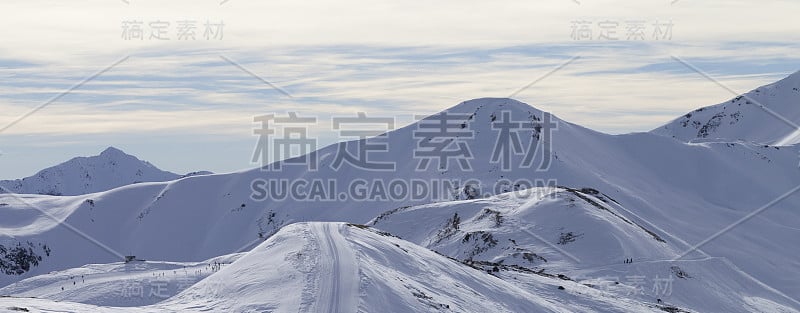 冬季有滑雪痕迹的高山，雪坡上的道路