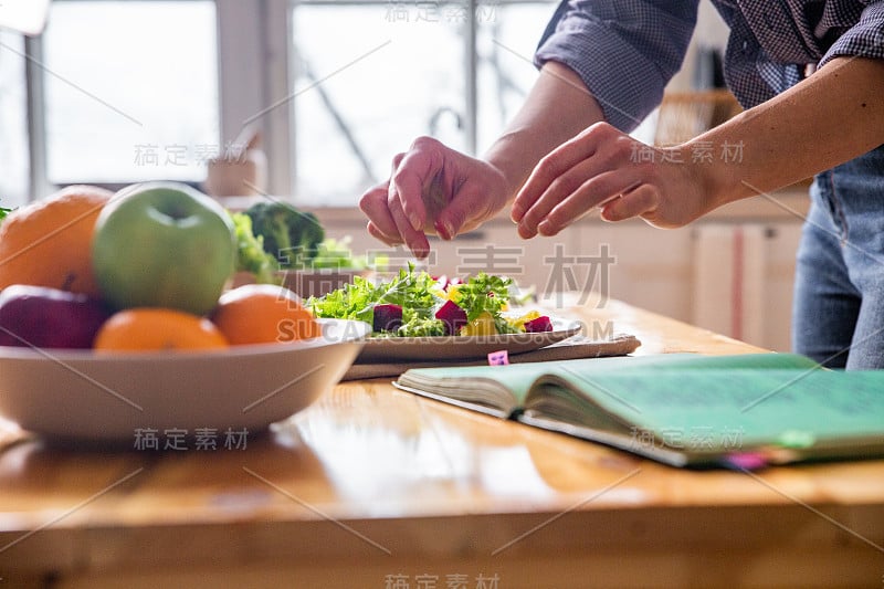 年轻漂亮的家庭主妇在白色的厨房里做饭