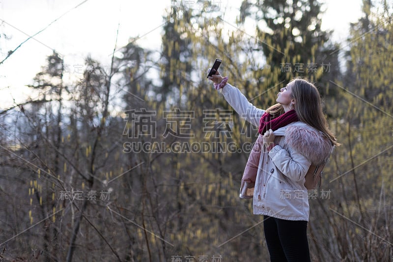 一个白人女孩用手机在户外自拍