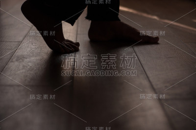 女人的腿放在温暖的木地板上