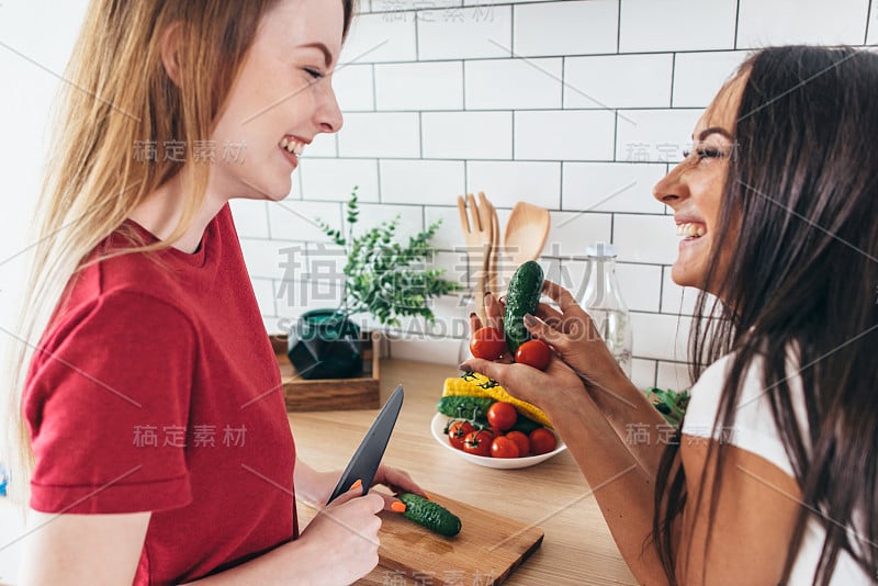 女人准备食物，在厨房里玩蔬菜玩得开心。