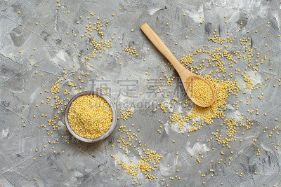 用勺子盛在碗里的生的、干的、去壳的小米